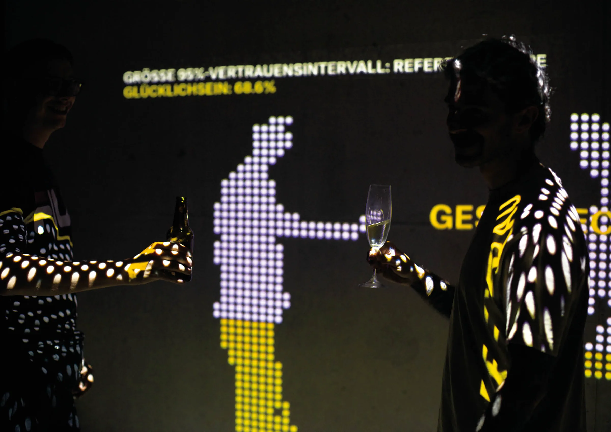 Two people beside a dot-matrix silhouette projection showing survey statistics
