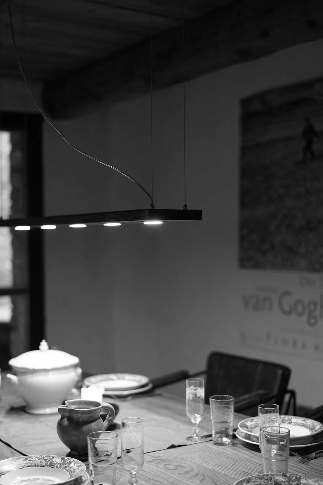 Black pendant lamp with four spotlights above a dining table, black and white