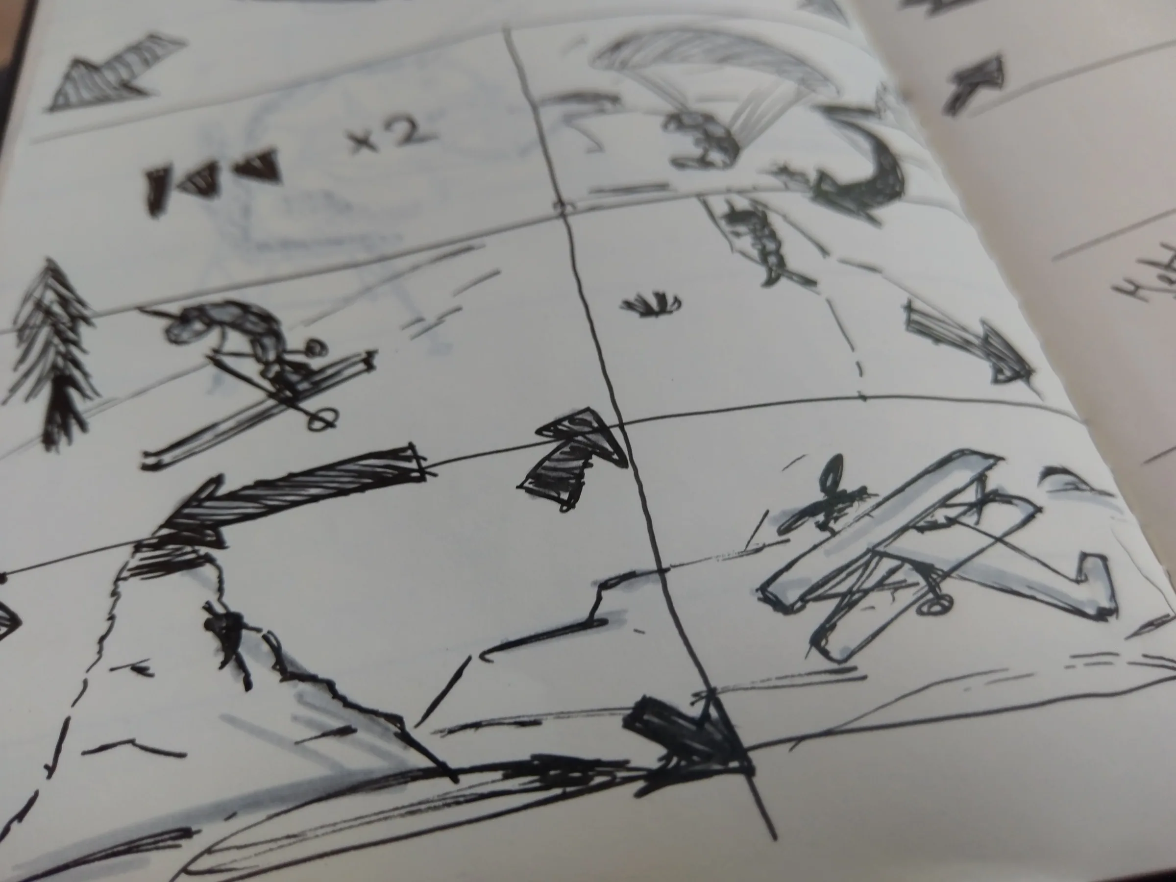 Storyboard sketches of skiing and flying figures in a notebook